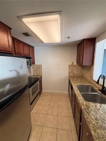 a kitchen with granite countertop a sink a stove and a microwave