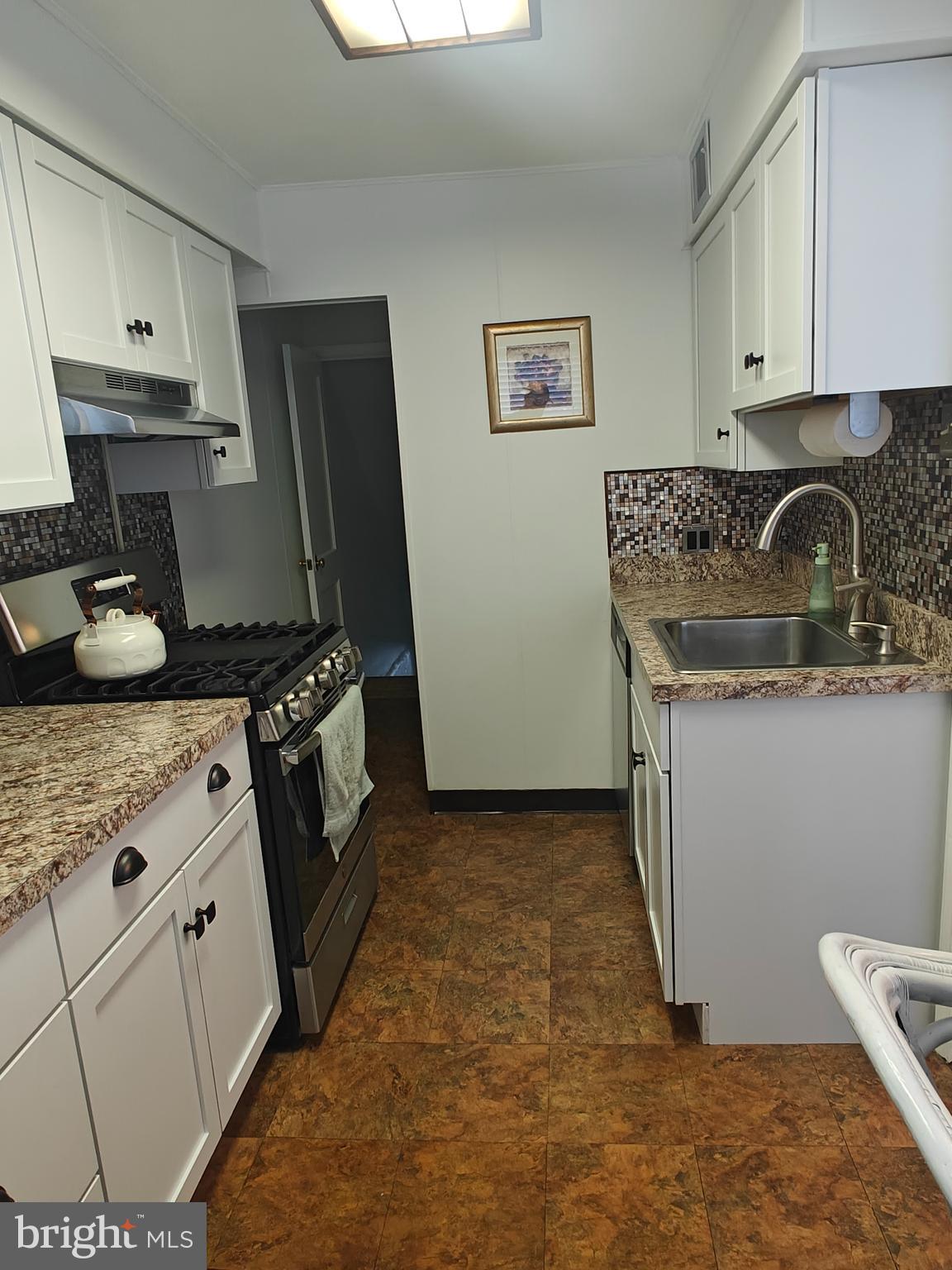 6448 Akron Street Philadelphia, PA 19149 - Photo 13 of 30 a kitchen with stainless steel appliances granite countertop a sink stove and refrigerator