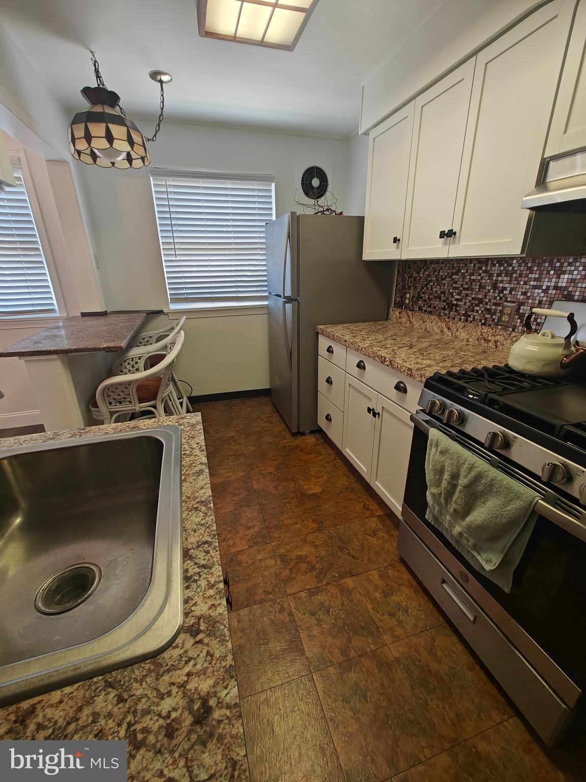 6448 Akron Street Philadelphia, PA 19149 - Photo 15 of 30 a kitchen with granite countertop a stove and a refrigerator