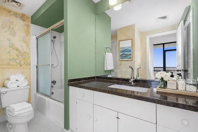 a bathroom with a granite countertop sink toilet and shower