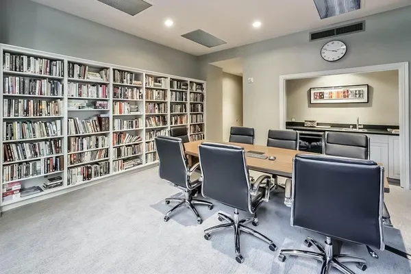 a view of a workspace with furniture and a bookshelf