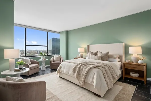 a large bedroom with a bed and large window