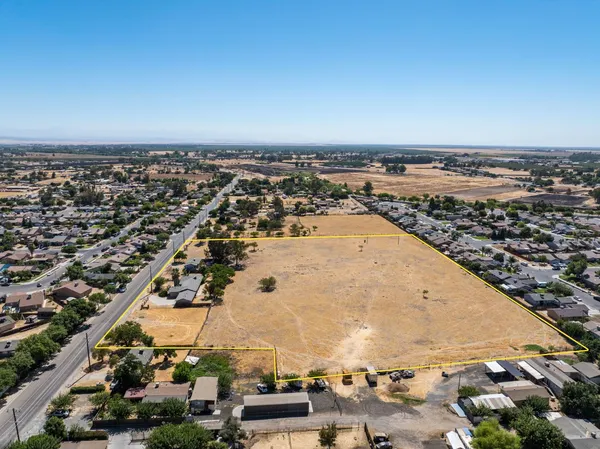 an aerial view of a house with a yard and parking
