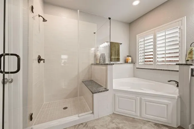 a bathroom with a bathtub a sink a window and a shower