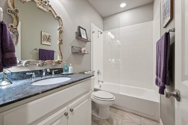 a bathroom with a granite countertop sink toilet and shower