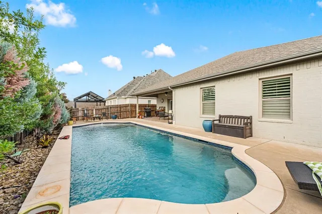 a swimming pool with outdoor seating and yard