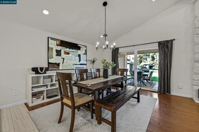 a dining room with furniture a rug and a floor to ceiling window