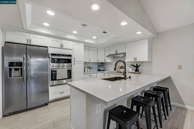 a kitchen with refrigerator cabinets and a sink
