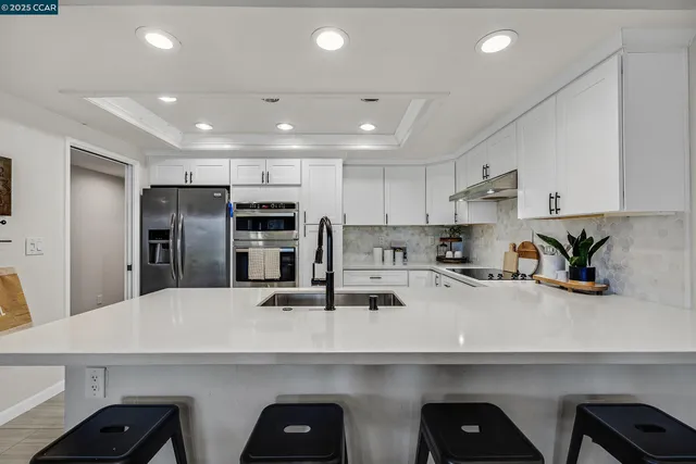 a kitchen with refrigerator and white cabinets