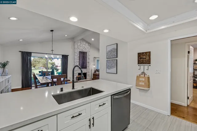 a kitchen with stainless steel appliances a sink a stove a refrigerator a counter space and cabinets