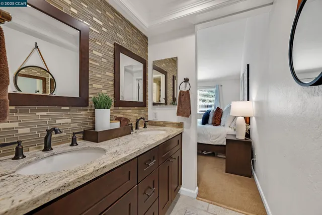 a en suite bathroom with a granite countertop sink and a mirror