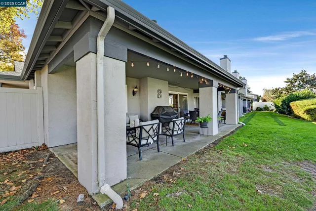 a view of a house with backyard and sitting area