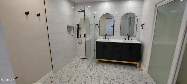 a bathroom with a double vanity sink and mirror