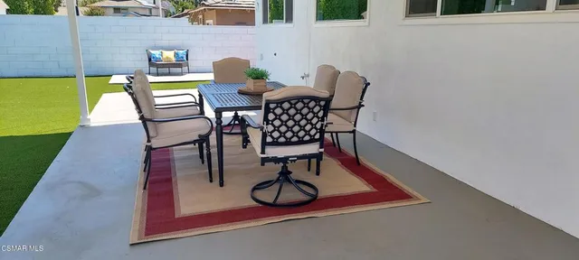 a view of patio with a table and chairs