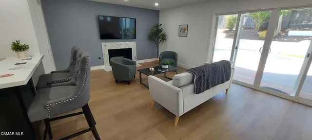 a living room with furniture a flat screen tv and a fireplace