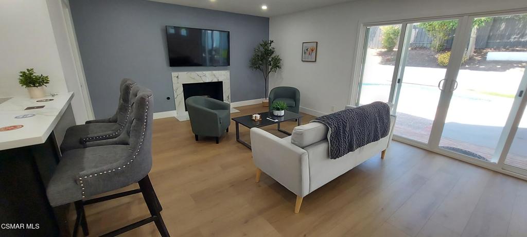 4071 Peoria Avenue Simi Valley, CA 93063 - Photo 9 of 19 a living room with furniture a flat screen tv and a fireplace
