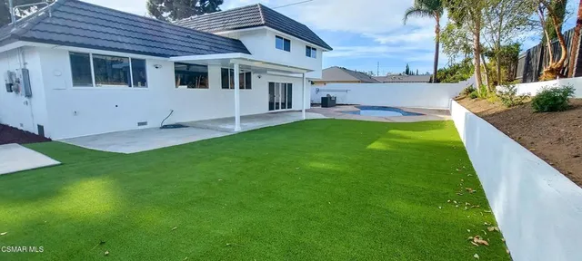 a backyard of a house with table and chairs