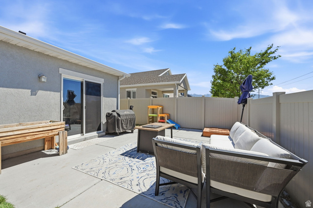 1175 Silver Hollow Road Syracuse, UT 84075 - Photo 29 of 34 Private concrete patio featuring a sliding glass door entry, stucco exterior, and full vinyl fencing