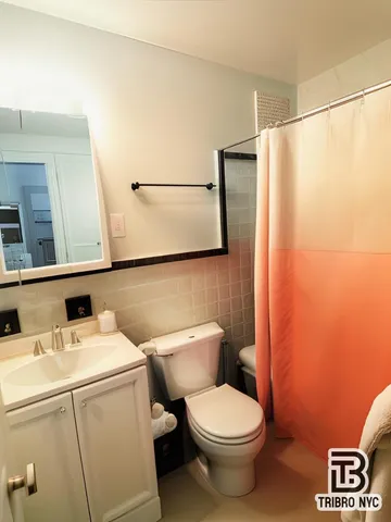 a white toilet sitting next to a white sink and vanity