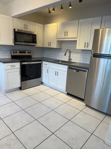 a kitchen with stainless steel appliances granite countertop a stove a sink and a refrigerator