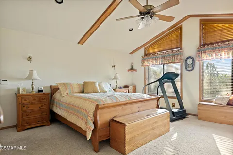 a bedroom with a bed a chandelier and dresser