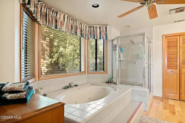 a bathroom with a tub a sink and a large window