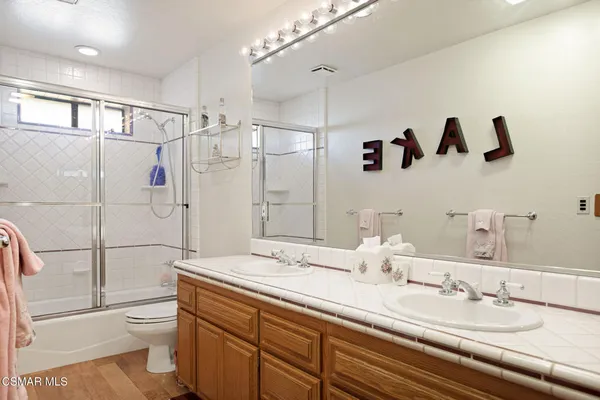 a bathroom with a double vanity sink toilet and shower