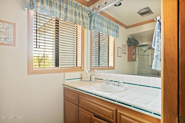 a bathroom with a granite countertop sink and mirror