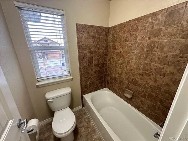 a white toilet sitting next to a bath tub and a shower