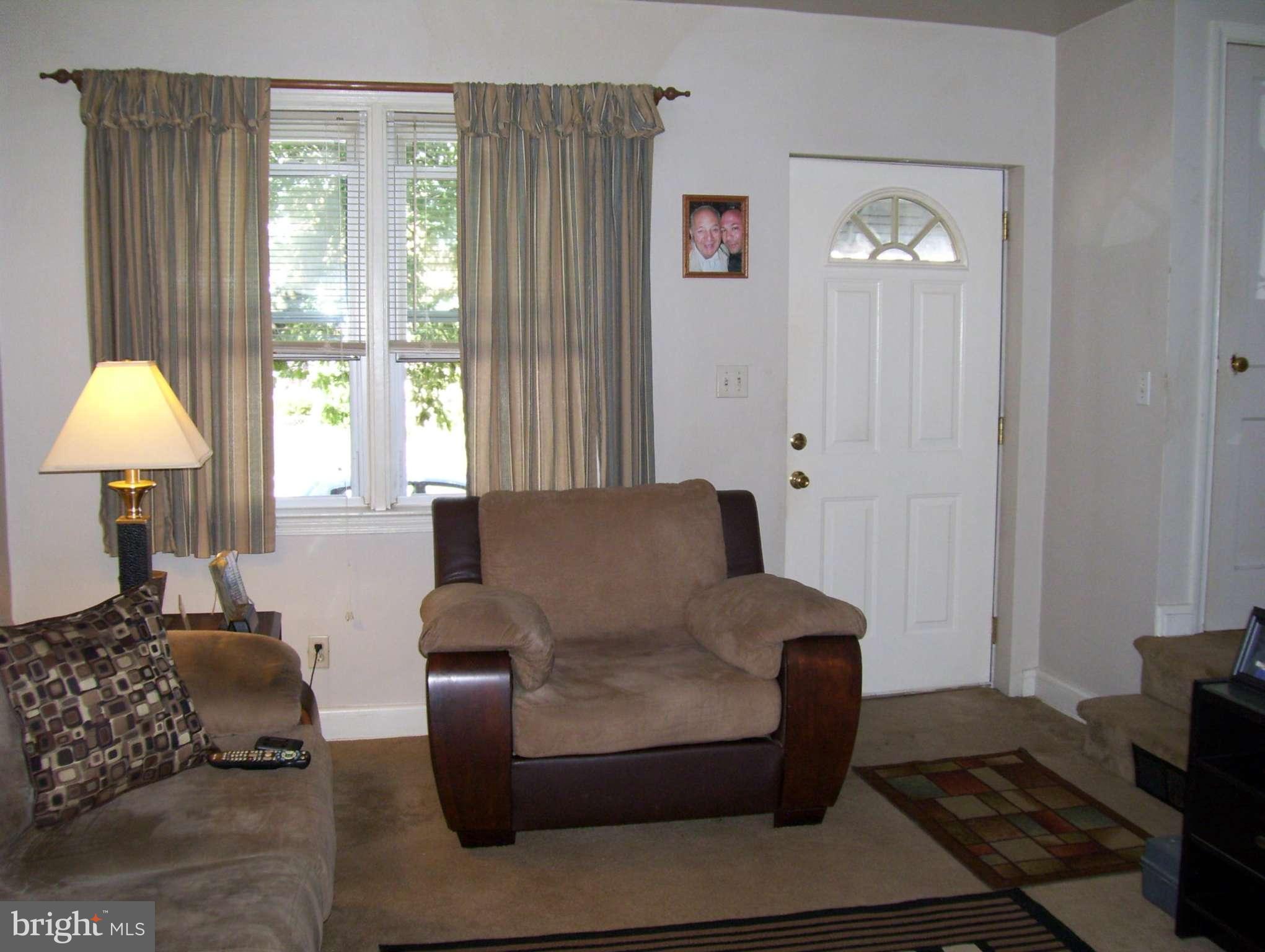 74 Wiltshire Road Baltimore, MD 21221 - Photo 2 of 11 a living room with furniture and a lamp