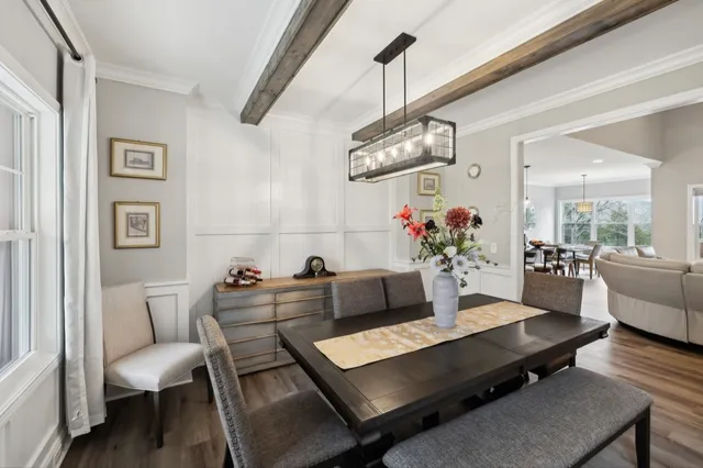 a kitchen with stainless steel appliances granite countertop a stove a sink a refrigerator a dining table chairs and couches with wooden floor