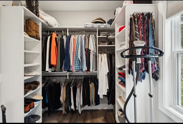 a view of a white house with a big yard and large trees