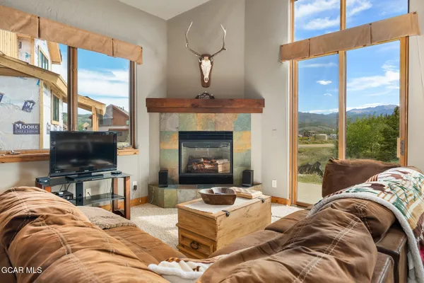 a living room with a couch a flat screen tv and a fireplace
