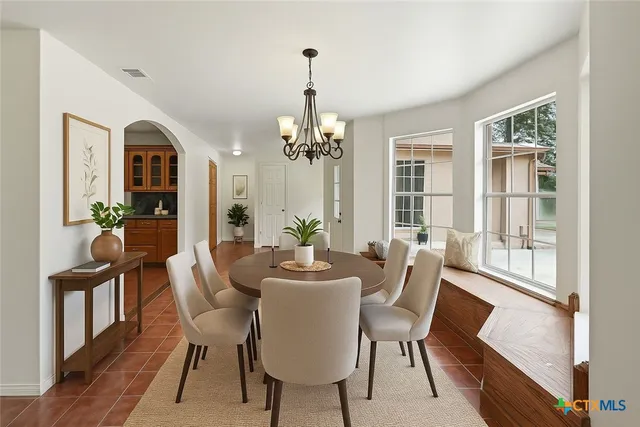a dining room with furniture a chandelier and wooden floor