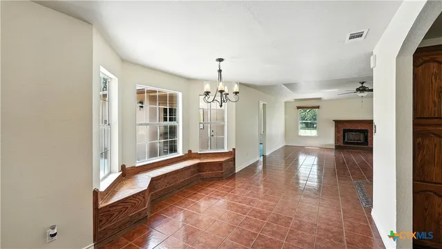 a view of a hallway with wooden floor and a kitchen