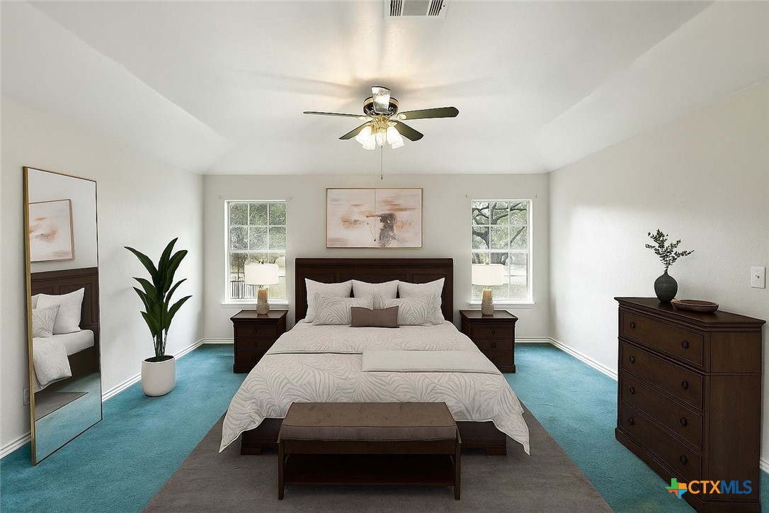 220 Lanier Ranch Road Driftwood, TX 78619 - Photo 19 of 48 a bedroom with a large bed and a chandelier fan