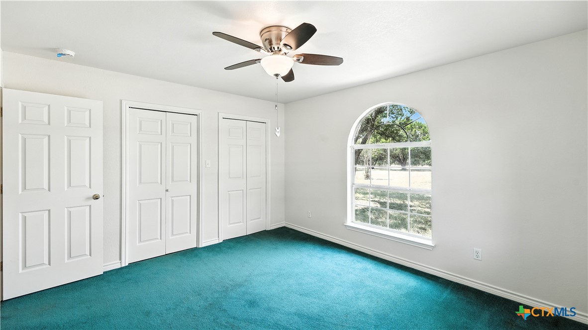 220 Lanier Ranch Road Driftwood, TX 78619 - Photo 27 of 48 an empty room with windows and fan