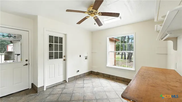 an empty room with windows and ceiling fan