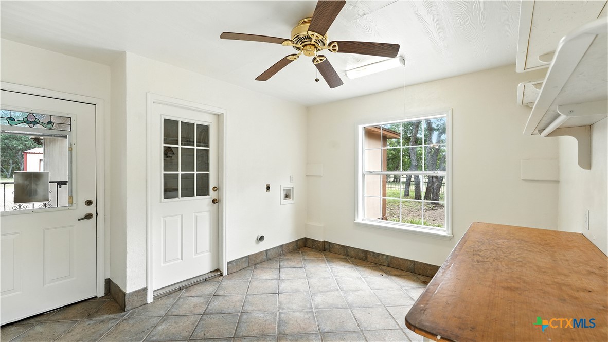 220 Lanier Ranch Road Driftwood, TX 78619 - Photo 29 of 48 an empty room with windows and ceiling fan