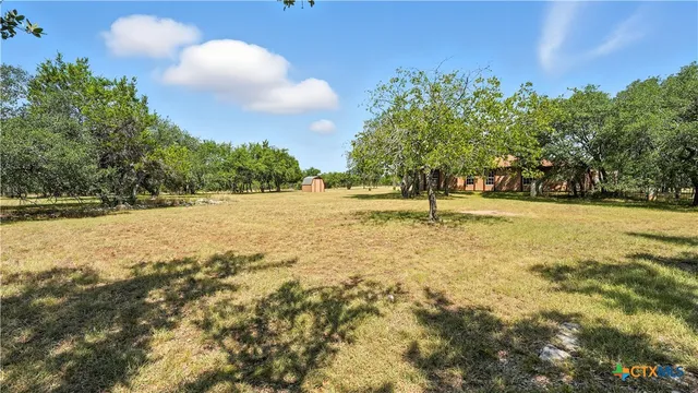 a backyard of a house with lots of green space and lake view