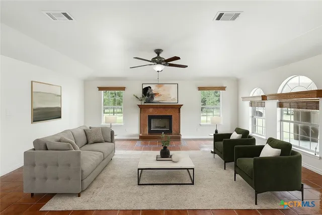 a living room with furniture a fireplace and a large window