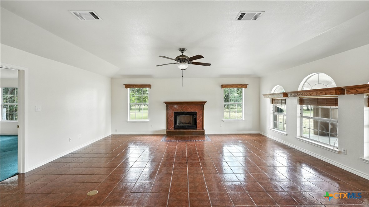 220 Lanier Ranch Road Driftwood, TX 78619 - Photo 7 of 48 a view of a livingroom with a fireplace a ceiling fan and windows