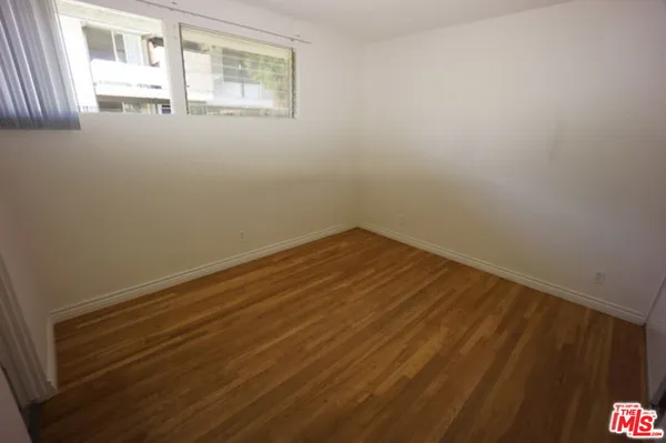 a view of a room with wooden floor and windows