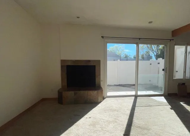 a living room with a fireplace and a floor to ceiling window