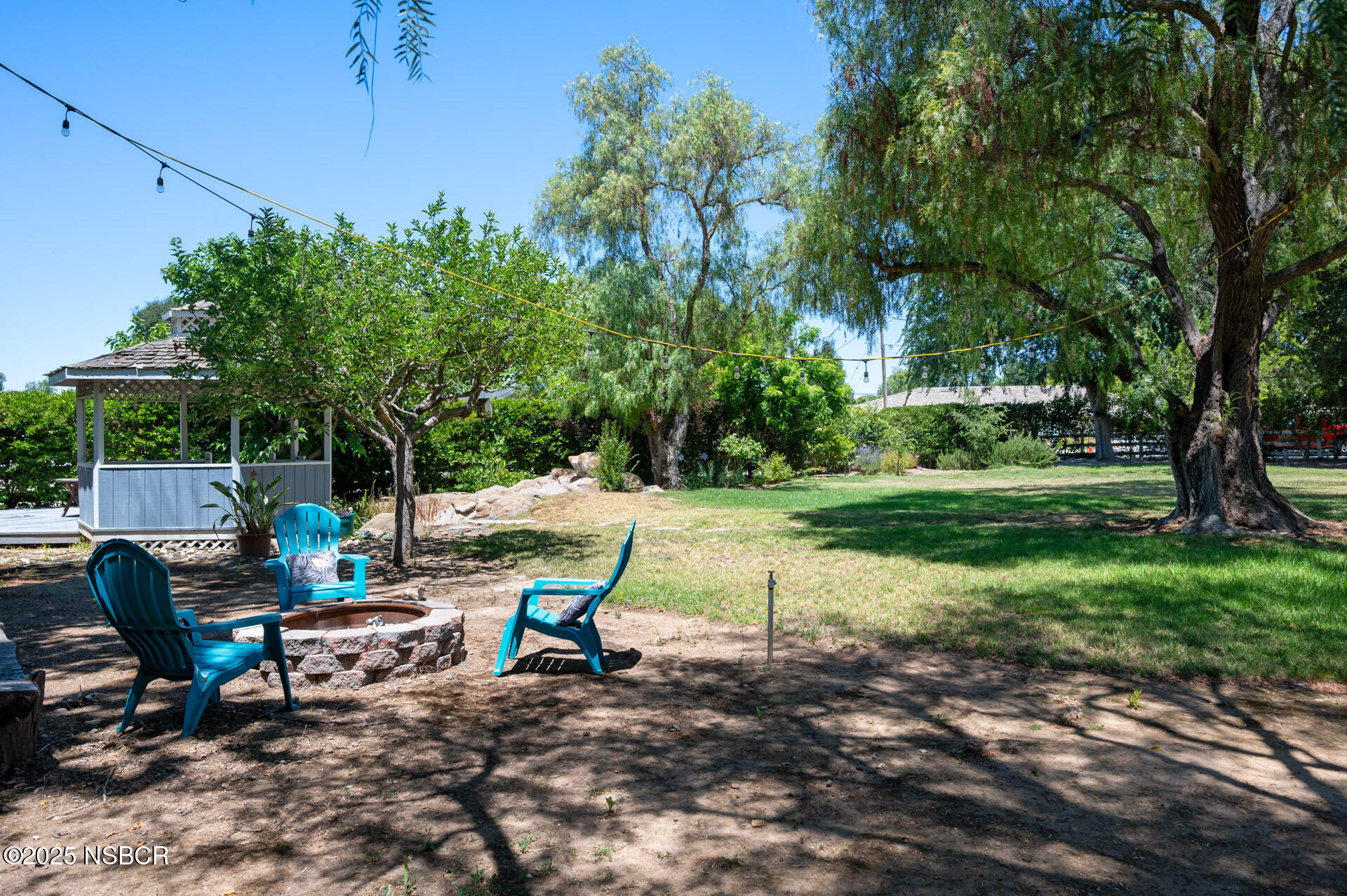 1011 North Refugio Road Santa Ynez, CA 93463 - Photo 30 of 48 a view of backyard with table and chairs and a large tree