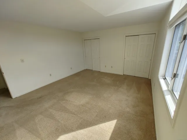 an empty room with windows and closet