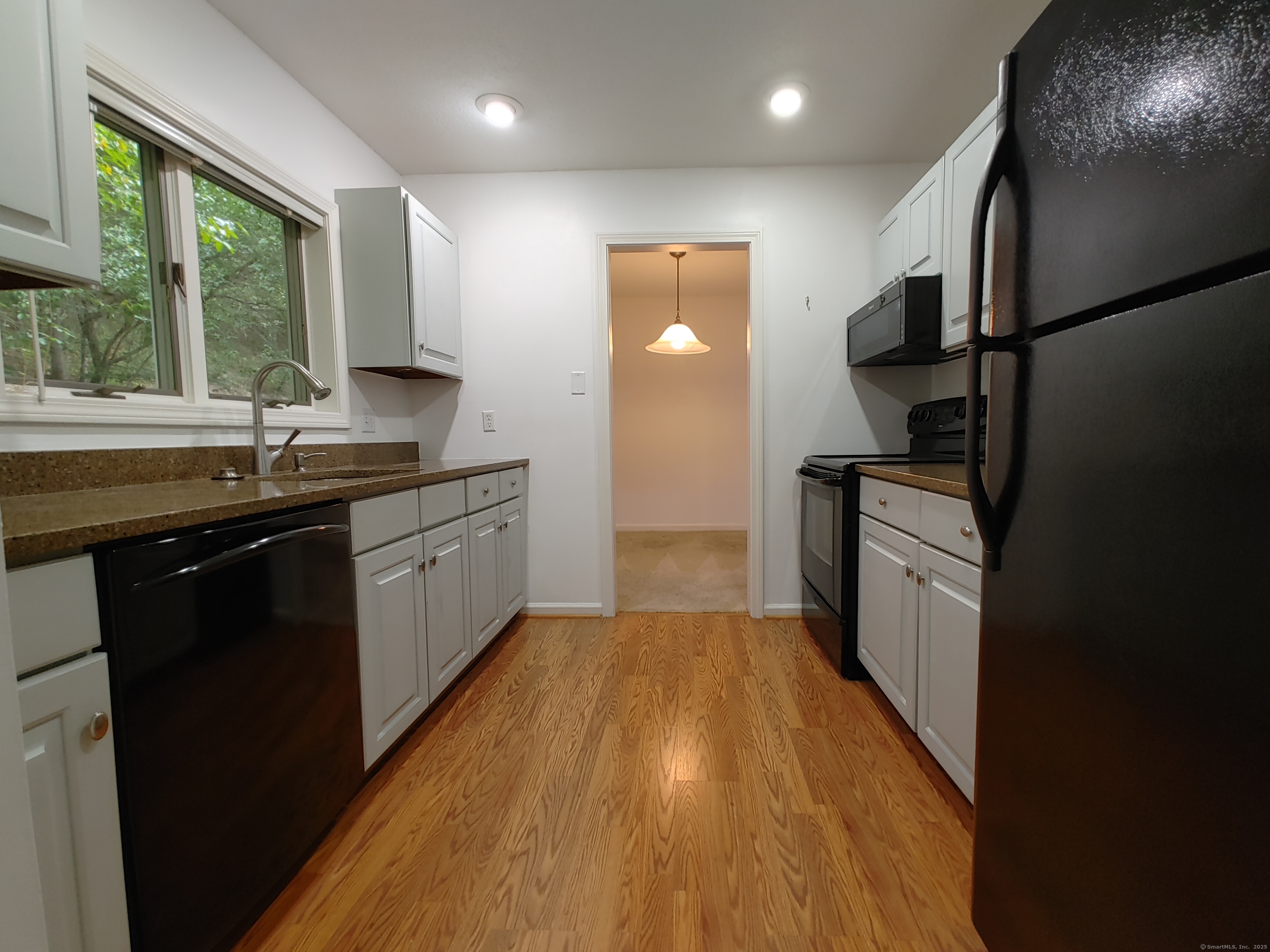 402 Whetstone Mills, Unit 402 Dayville, CT 06241 - Photo 2 of 21 a kitchen with granite countertop a sink a counter top space stainless steel appliances a window and a counter space