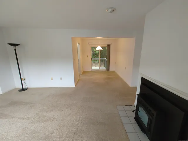 a view of a room with an empty space and a fireplace