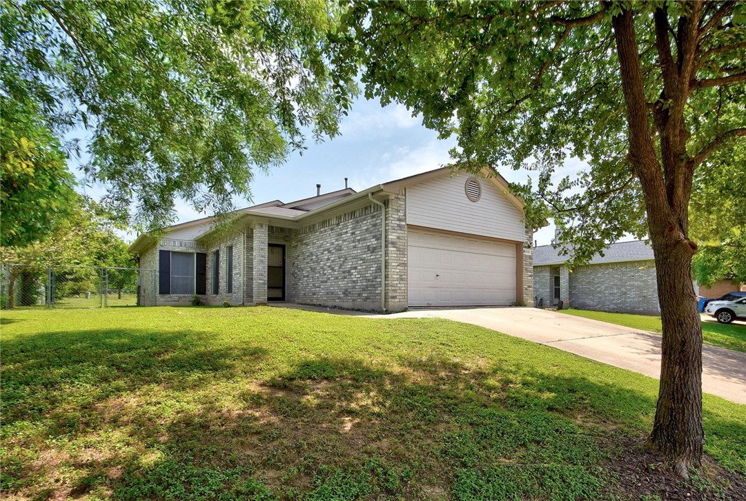 a front view of house with yard and trees