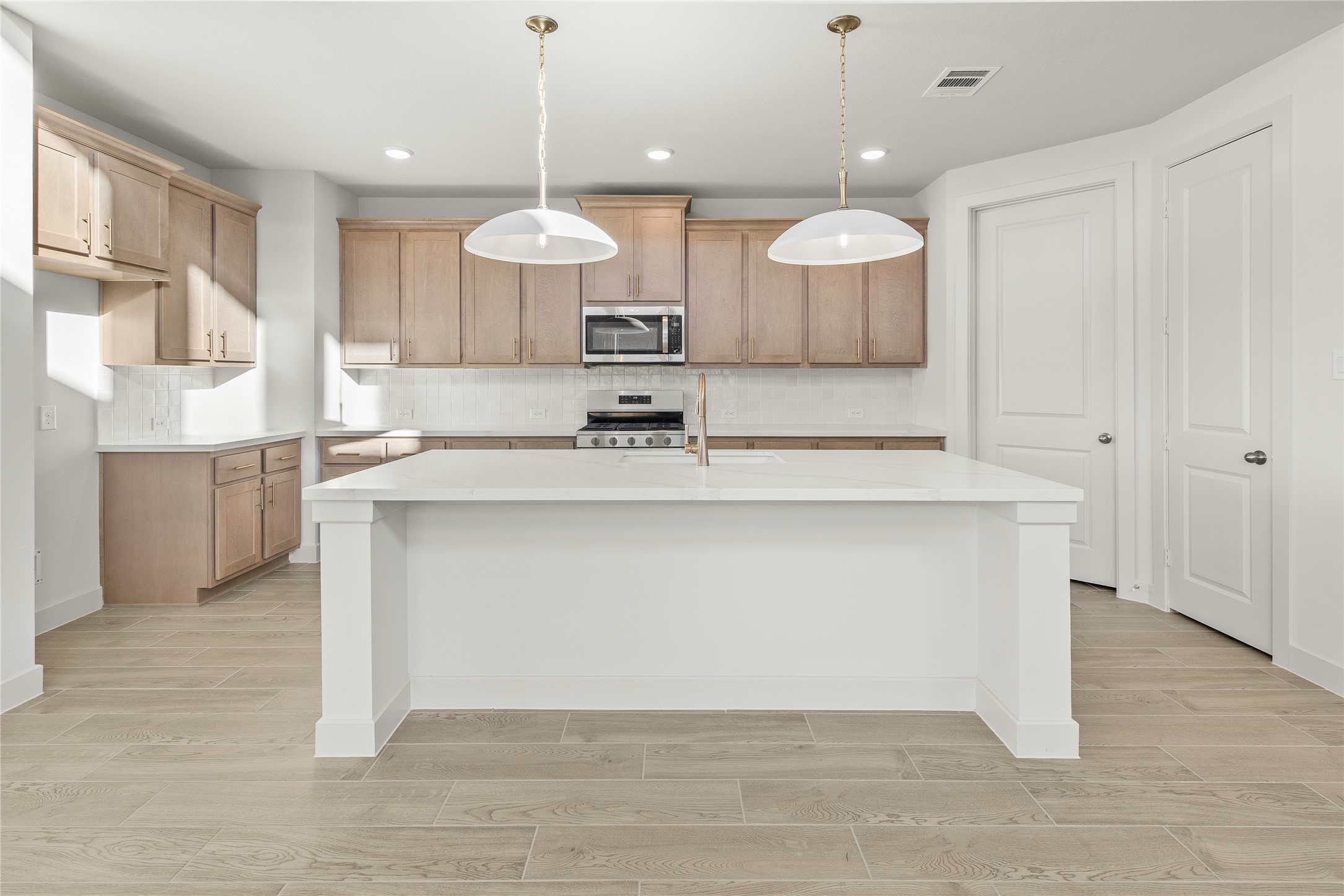 206 Sierra Stream Lane Conroe, TX 77304 - Photo 5 of 28 a large kitchen with a large counter top a sink a center island and stainless steel appliances